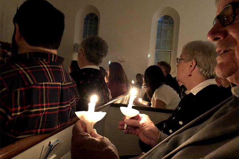 People holding candles and singing in the church