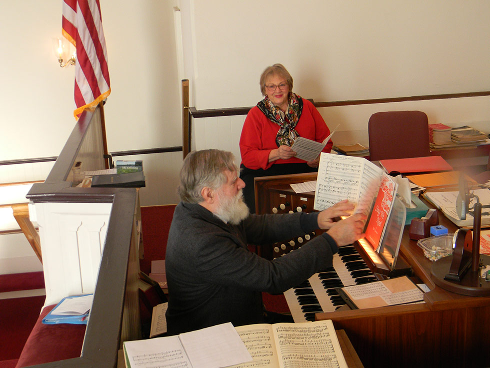 Music Director Charlie Confer rehearses with choir member Cheri Christakis