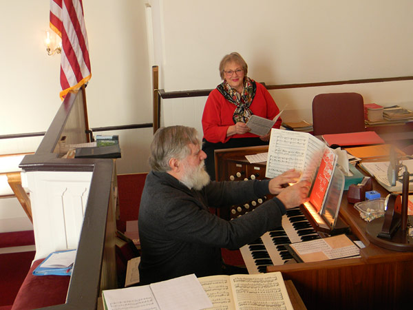 Music Director Charlie Confer rehearses with choir member Cheri Christakis