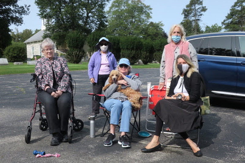 Church members wearing masks gathered in the church parking lot