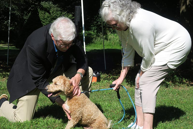 Photo of Pastor Loring blessing a dog