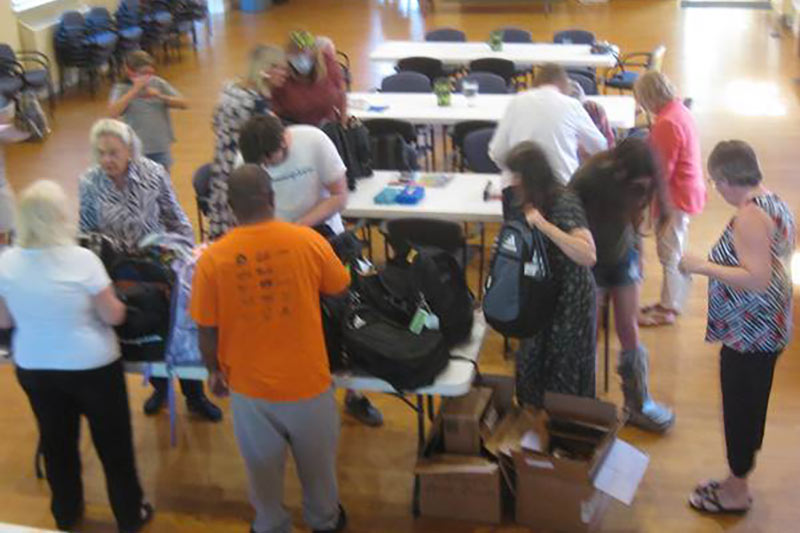 Photo of food cupboard volunteers packing backpacks