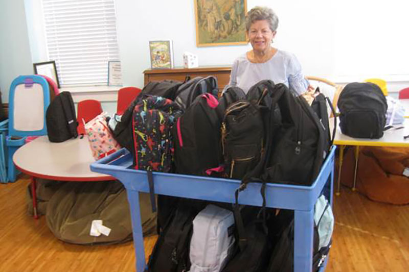 Photo of food cupboard volunteers packing backpacks