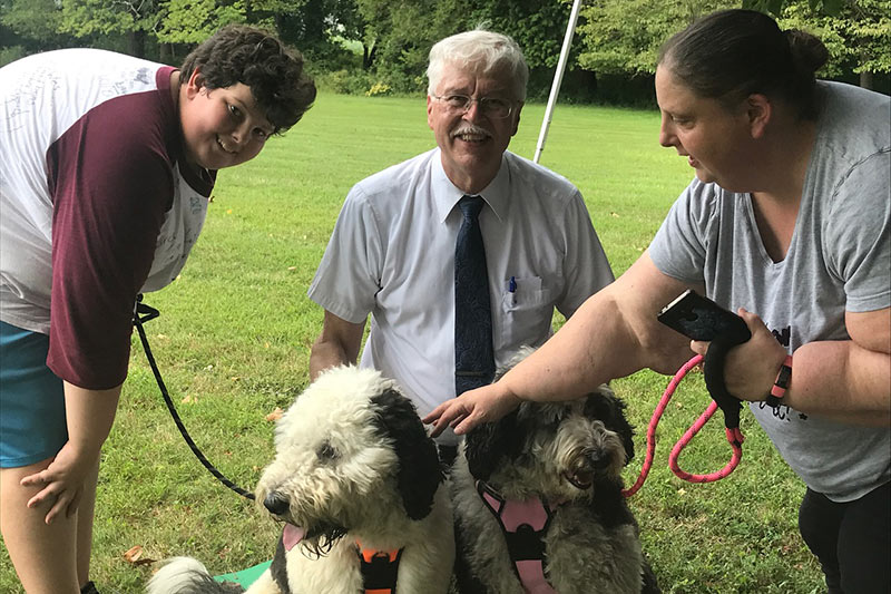 Photo of pastor Loring blessing two dogs