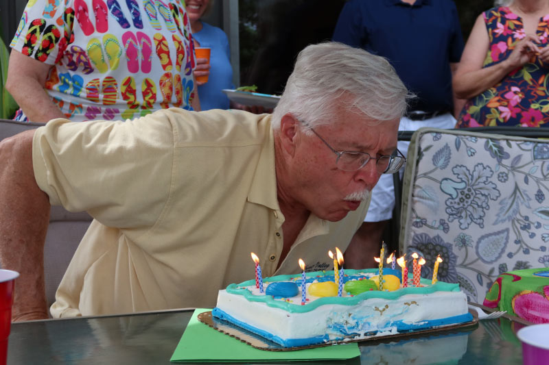 Photo of pastor Loring blowing out candles on a birthday cake