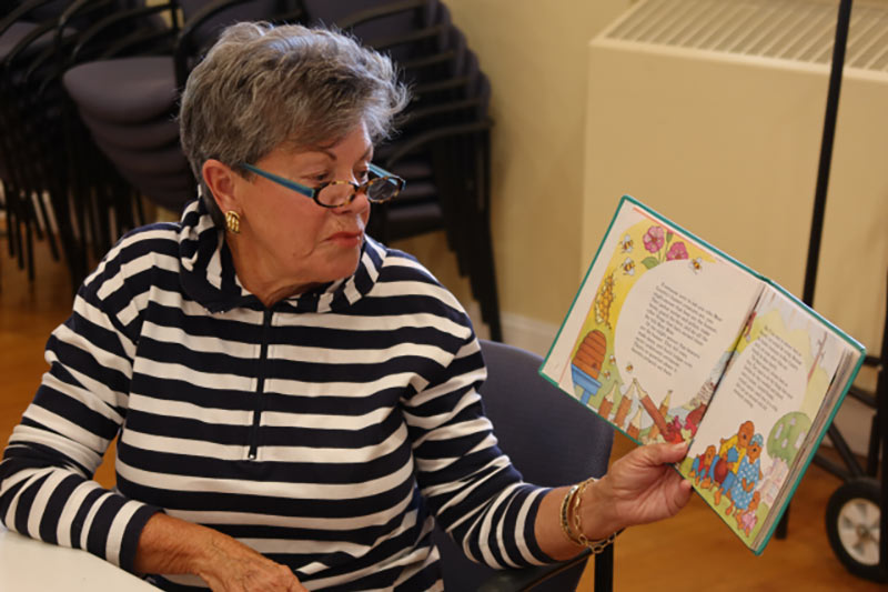 Photo of Lynda reading a book out loud