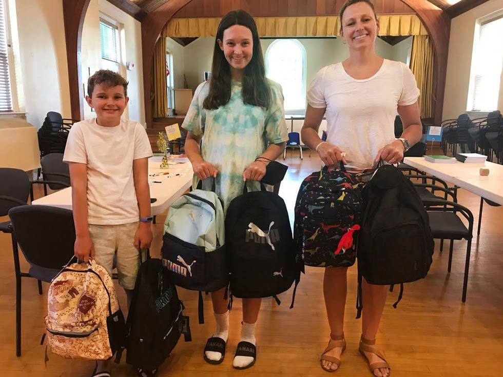 Photo of church members holding up backpacks
