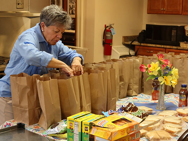 Photo of a church volunteer filling bags of donated food