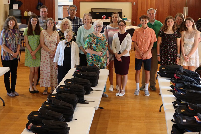 Photo of church members with backpacks for students